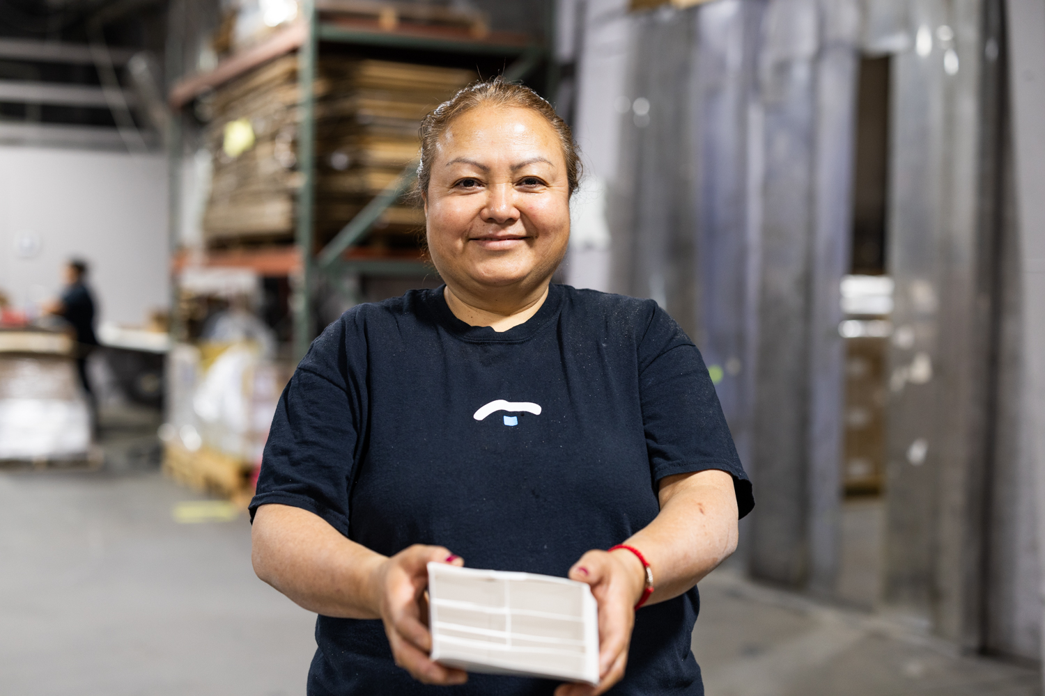 Secondary Solutions female team member holding a product prepared by Secondary Solutions, smiling at the camera